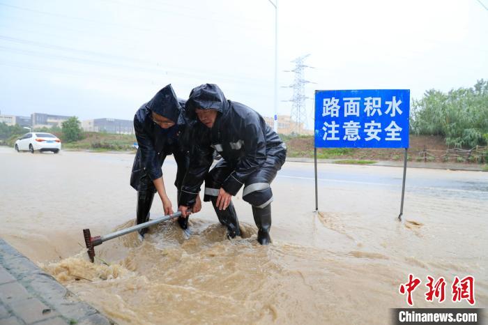 合肥庐阳经开区城管队员正在淮北路和天河路段进行紧急排水处理。　赵明 摄