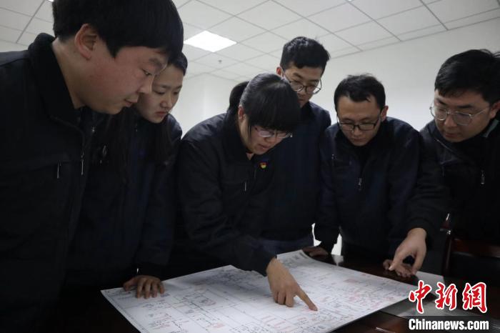 图为晏相芝带领团队研判问题。　杨睿 摄