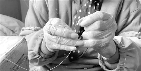 101岁老母亲给61岁儿子缝纽扣 儿子朋友圈里晒幸福