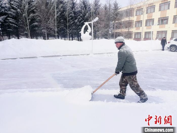 清雪工人正在清雪，帽子、肩膀上落满了雪花。冯宏伟 摄