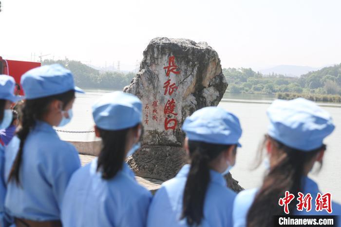 图为一群身着红军服的学生在长征第一渡口前开展研学教育活动。　刘力鑫 摄