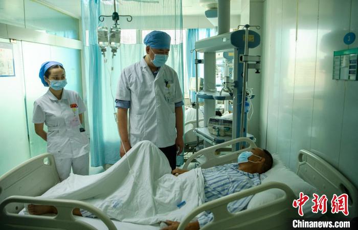 8月13日，医生查看患者父亲康复情况。　刘忠俊 摄