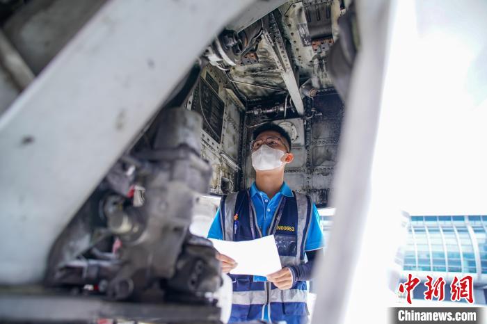 图为航线维护工程师对飞机进行检查。　陈冠言 摄